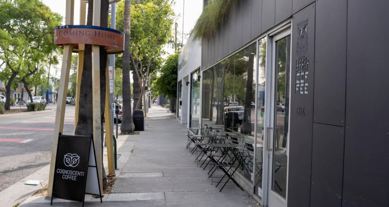 The storefront sidewalk sign and patio seating at Cognoscenti Coffee